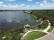 Scenic aerial view of a community lake, featuring lush trees, a gazebo, and walking trails by the waterfront at 6669 Windjammer Pl, Lakewood Ranch, FL 34202