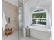Modern bathroom featuring a soaking tub, glass-enclosed shower, and a view of the outside at 6669 Windjammer Pl, Lakewood Ranch, FL 34202