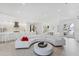 Open-concept living area with sleek white furniture and access to a modern kitchen at 6669 Windjammer Pl, Lakewood Ranch, FL 34202