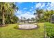 Beautiful backyard with a circular brick patio, lush greenery, and a view of the waterfront at 121 Holly Ave, Sarasota, FL 34243