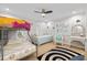 Light-filled bedroom with a bunk bed, daybed and wicker desk illuminated by a modern ceiling fan at 121 Holly Ave, Sarasota, FL 34243