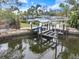 Waterfront property showcasing a private boat lift and dock, ideal for boating enthusiasts and enjoying waterfront living at 121 Holly Ave, Sarasota, FL 34243