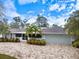 Beautiful one-story home with a brick driveway, two-car garage, mature landscaping, and screened in porch at 121 Holly Ave, Sarasota, FL 34243