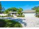 Charming single-story home features lush landscaping, a wide driveway, and a two-car garage at 121 Holly Ave, Sarasota, FL 34243