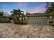 Charming single-story home featuring a two-car garage and mature landscaping, highlighted by an expansive brick-paved driveway at 121 Holly Ave, Sarasota, FL 34243
