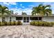 Charming single story home with lush landscaping, a brick driveway, and a screened in porch at 121 Holly Ave, Sarasota, FL 34243