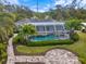 Aerial view of a screened-in pool and hot tub, surrounded by lush landscaping and a brick-paved patio at 121 Holly Ave, Sarasota, FL 34243