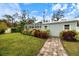Backyard shed with brick pathway surrounded by lush, colorful landscaping at 121 Holly Ave, Sarasota, FL 34243