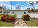 Backyard shed with a lush, colorful garden and brick pathway at 121 Holly Ave, Sarasota, FL 34243