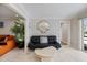 Cozy sitting area featuring a black sofa, statement mirror, and tiled flooring, adjacent to large sliding doors at 121 Holly Ave, Sarasota, FL 34243