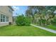 Well-maintained backyard featuring lush green grass and a concrete path, providing a serene outdoor space at 12471 Natureview Cir, Bradenton, FL 34212