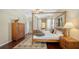 Comfortable main bedroom featuring a four-poster bed, hardwood floors, and ample natural light at 12471 Natureview Cir, Bradenton, FL 34212