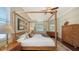 Comfortable main bedroom featuring a four-poster bed, hardwood floors, and ample natural light at 12471 Natureview Cir, Bradenton, FL 34212