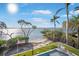A backyard view shows a swimming pool, a manicured lawn and waterfront views with palm trees at 12917 42Nd W Ter, Cortez, FL 34215