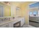 Well-lit bathroom with double vanity and access to the primary bedroom at 12917 42Nd W Ter, Cortez, FL 34215