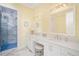 Bathroom with dual sinks, vanity, and walk-in shower with marble accents at 12917 42Nd W Ter, Cortez, FL 34215