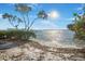 Sandy beach meets calm water in this waterfront property with partial views of a pier at 12917 42Nd W Ter, Cortez, FL 34215