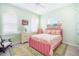 Charming bedroom with a pink flamingo-themed bed, shuttered windows, and soft green walls at 12917 42Nd W Ter, Cortez, FL 34215