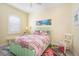 Cozy bedroom with a beach-themed artwork, a quilt-patterned bedding, and shuttered window at 12917 42Nd W Ter, Cortez, FL 34215