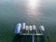 Aerial view of boat dock featuring multiple boat slips with lifts and canopies in a waterfront setting at 12917 42Nd W Ter, Cortez, FL 34215