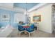 Dining area with glass table, blue chairs, and views into the living room at 12917 42Nd W Ter, Cortez, FL 34215