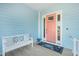 Comfortable porch area with a white bench and cheerful pink front door at 12917 42Nd W Ter, Cortez, FL 34215