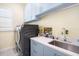 Modern laundry room with blue cabinets, a large sink, and a high-efficiency washer and dryer at 12917 42Nd W Ter, Cortez, FL 34215