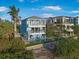 Three-story home with balconies, a backyard pool, and lush landscaping against a blue sky at 12917 42Nd W Ter, Cortez, FL 34215
