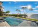 The swimming pool features sparkling blue water, water views, landscaping and an American flag at 12917 42Nd W Ter, Cortez, FL 34215