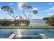 The swimming pool features waterfront views and an American flag along the back fence row at 12917 42Nd W Ter, Cortez, FL 34215
