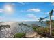 A waterfront view shows sandy beach, a dock, and calm water on a sunny day at 12917 42Nd W Ter, Cortez, FL 34215