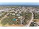 Aerial view of community featuring a pool, tennis court, ponds, and mature landscaping at 20032 Sancraft Ave, Port Charlotte, FL 33954