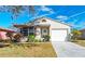 Charming single-story home featuring a well-maintained lawn, lush landscaping, and attached two-car garage at 20032 Sancraft Ave, Port Charlotte, FL 33954