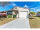 Charming single-story home featuring a well-manicured lawn, one-car garage, and inviting entrance with natural light at 20032 Sancraft Ave, Port Charlotte, FL 33954