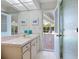 Bathroom sink featuring cabinet storage and doorway leading to the screened lanai at 5259 Everwood Run, Sarasota, FL 34235