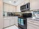 This kitchen features modern appliances, granite countertops, and crisp white cabinets at 5259 Everwood Run, Sarasota, FL 34235