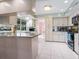 Bright kitchen featuring an island, crisp white cabinets, modern appliances, and stone countertops at 5259 Everwood Run, Sarasota, FL 34235