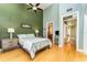 Bedroom featuring a ceiling fan, wood floors, and ensuite bathroom access at 559 Bahia Beach Blvd, Ruskin, FL 33570