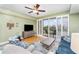 Bright living room with wood floors, ceiling fan, and sliding door to balcony at 559 Bahia Beach Blvd, Ruskin, FL 33570
