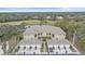 An aerial view of the condo with tile roof, garages, landscaping, and a peaceful golf course and pond in the background at 6334 Grand Oak Cir # 201, Bradenton, FL 34203