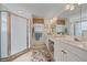 A bathroom features a glass enclosed shower, a double vanity, and tiled floor at 6334 Grand Oak Cir # 201, Bradenton, FL 34203