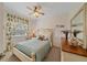 This cozy bedroom features a decorative ceiling fan, plush bedding, and floral curtains at 6334 Grand Oak Cir # 201, Bradenton, FL 34203