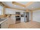 A modern kitchen features white cabinets, stainless steel appliances, and tile flooring at 6334 Grand Oak Cir # 201, Bradenton, FL 34203