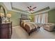 A spacious main bedroom with neutral carpeting, tray ceiling, ceiling fan, and natural lighting at 6334 Grand Oak Cir # 201, Bradenton, FL 34203