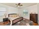 Comfortable bedroom featuring a ceiling fan, wood floors, and a decorative rug at 6814 Willowshire Way, Bradenton, FL 34212