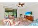 Bright living room with tile floors, ceiling fan, comfortable seating and large window to screened porch at 6814 Willowshire Way, Bradenton, FL 34212