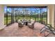 Screened patio with brick floors, cozy seating area, and open view of the lawn at 6814 Willowshire Way, Bradenton, FL 34212