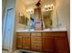 Bathroom featuring dual sinks, wooden vanity, and stylish decorative accents at 7619 Teal Trace, Bradenton, FL 34203