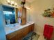 Bathroom featuring dual sinks, wooden vanity, and stylish decorative accents at 7619 Teal Trace, Bradenton, FL 34203