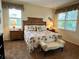 Bedroom featuring plantation shutters, ceiling fan, and a bed with palm tree patterns at 7619 Teal Trace, Bradenton, FL 34203